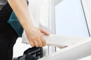 Professional handyman installing window at home.